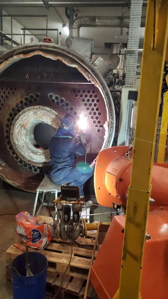 Soudeur intervenant à l'intérieur d'une chaudière industrielle